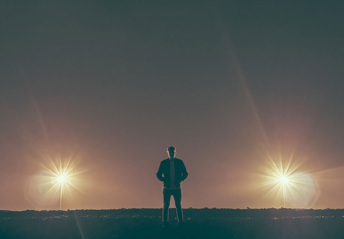 man standing between two flares trinity esoterics