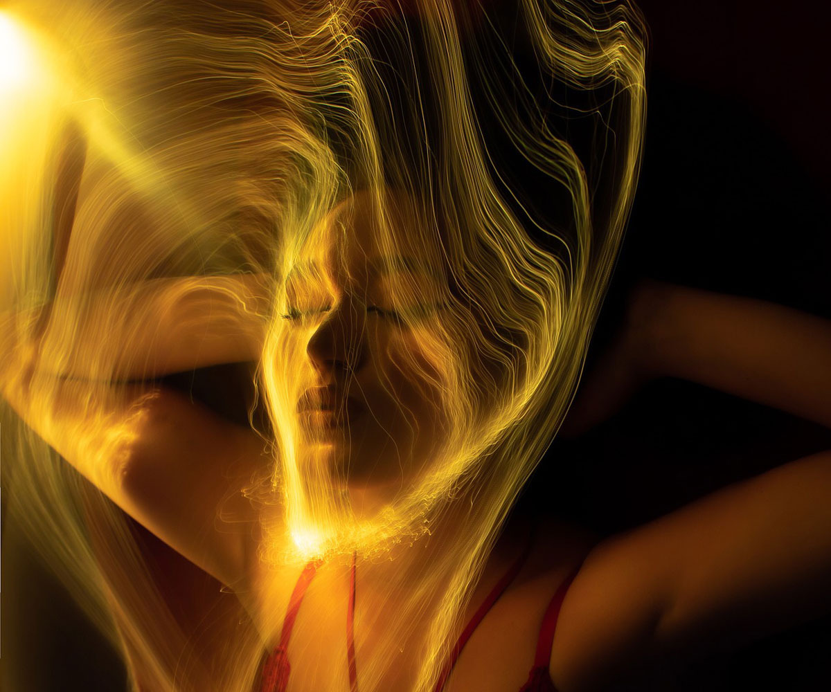 woman bathed in golden energy trinity esoterics