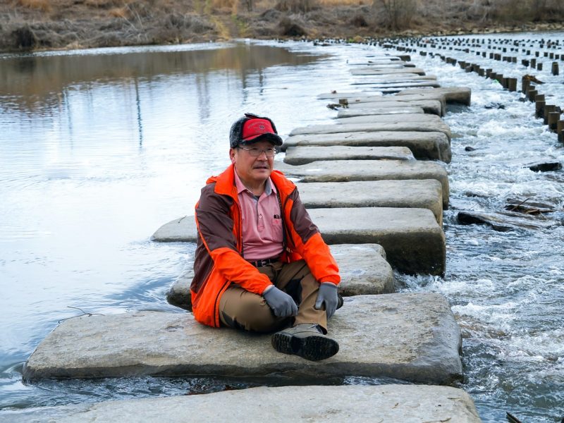 man sitting in the middle of stepping stones trinity esoterics