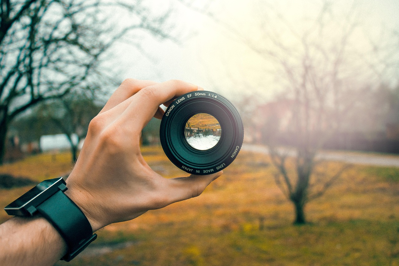 person holding up camera lens trinity esoterics