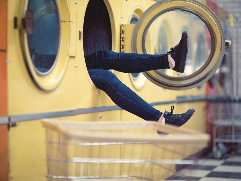 legs sticking out of a machine at a laundry mat trinity esoterics