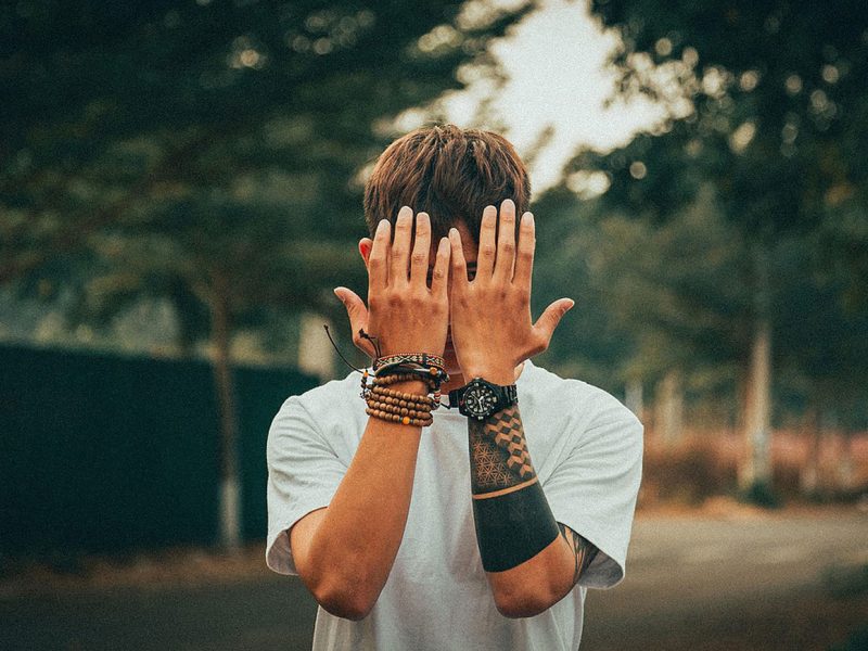 man hiding behind hands trinity esoterics